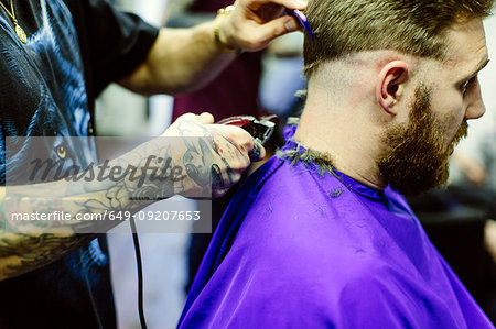 Close up of barber clipping clients hair