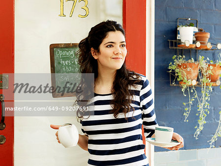 Young female waitress serving coffee outdoors