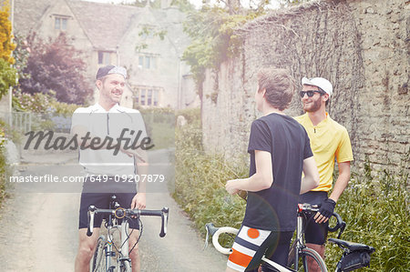Cyclists stopping by stone wall, Cotswolds, UK