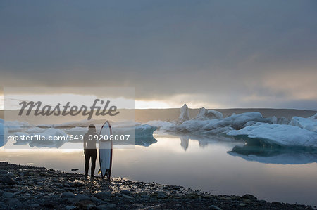 Woman with surfboard, Jokulsarlon Glacier Lagoon, Skaftafell National Park, Iceland Woman with surfboard, Jokulsarlon Glacier Lagoon, Skaftafell National Park, Iceland
