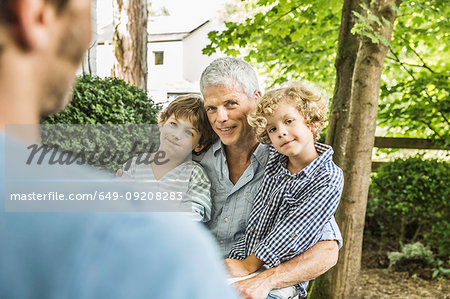 Mid adult man with father and sons in garden