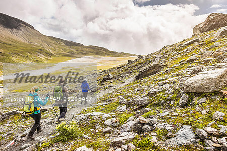 Male and female hikers hiking along path, Fil de Cassons, Segnesboden, Graubunden, Switzerland