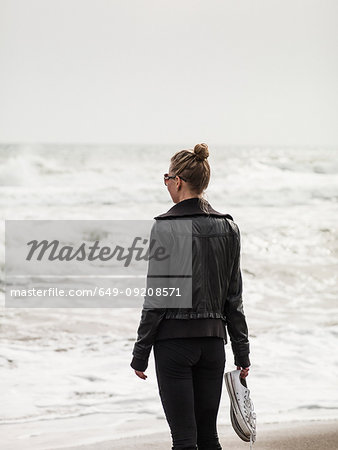 Rear view of mid adult woman looking out to sea, Torreblanca, Andalucia, Spain