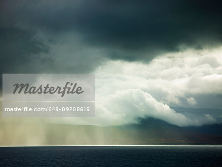 Storm clouds and sunlight over ocean, Isle of Jura, Hebrides, Scotland, UK