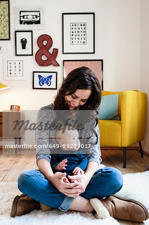 Mother and baby son sitting in living room
