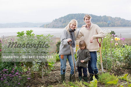 Portrait of couple and son digging organic garden, Orust, Sweden