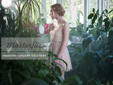 Young woman, in bathroom filled with plants