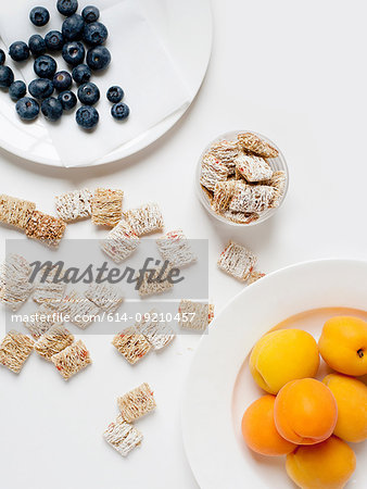 Still life with cereal and plate of apricots and blueberries