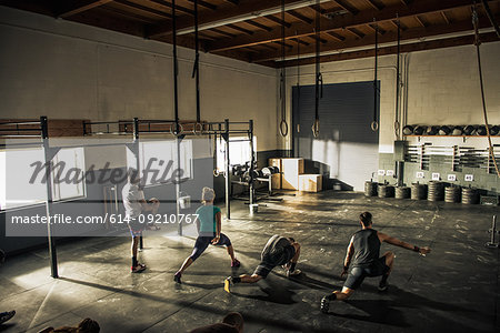 Fitness class warming up together in gym