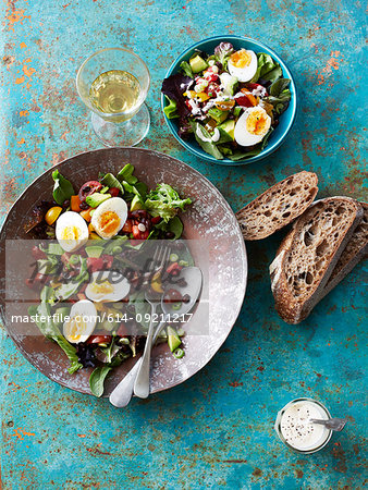 Still life of salad with boiled eggs, beans and brown bread