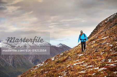 Female hiker hiking on steep mountain, Wrangell St. Elias, Alaska, USA