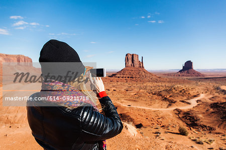 Mid adult woman photographing Monument Valley on smartphone, Utah, USA