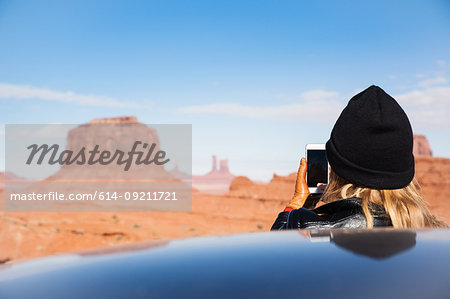 Rear view of mid adult woman photographing Monument Valley on smartphone, Utah, USA