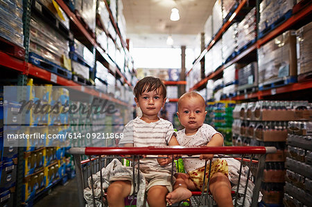 Brothers sitting in shopping trolley