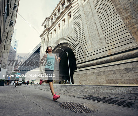 Young woman running in Dumbo, Brooklyn, New York, USA