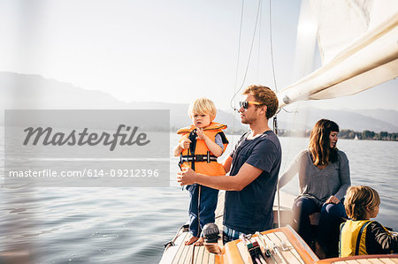 Mother and father with sons on sailboat