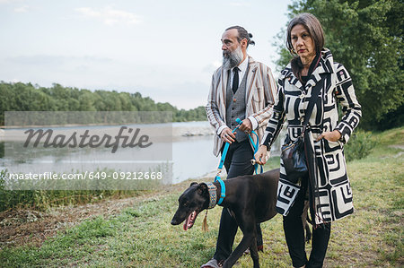 Couple walking dog by lake