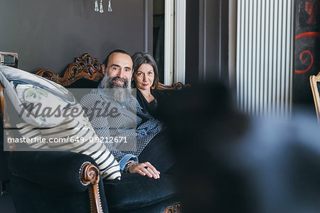 Couple on sofa looking at camera