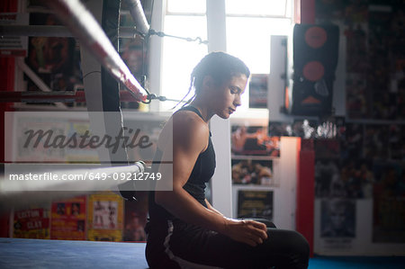 Female boxer by boxing ring