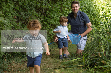 Father and children with fishing net in park