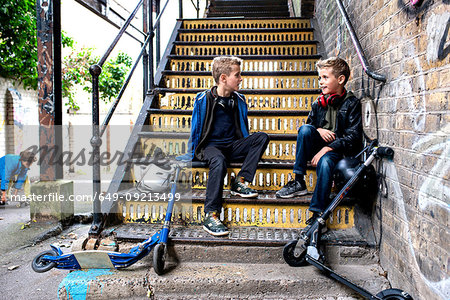 Twins talking on metal staircase