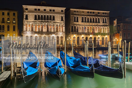 Gondolas on Grand canal waterfront at night, Venice, Veneto, Italy