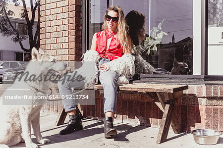 Young woman with pet dog at shopfront