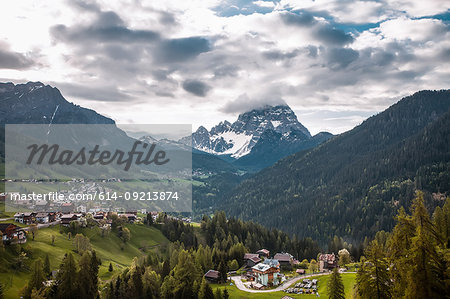 Landscape with valley villages and snow capped mountains, Dolomites, Italy
