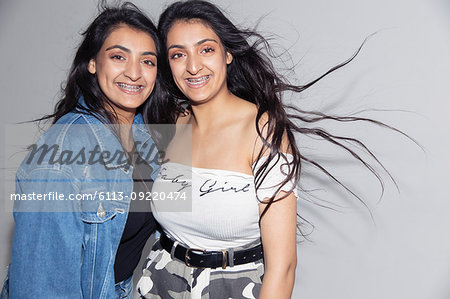 Portrait smiling, confident teenage twin sisters with braces