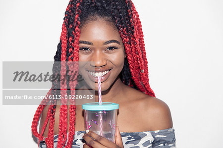 Portrait smiling, confident teenage girl drinking smoothie