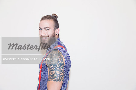 Portrait confident male hipster with shoulder tattoo