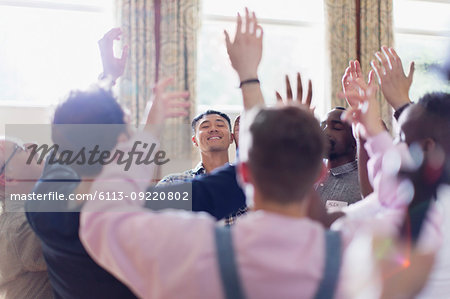 Men praying with arms raised in prayer group