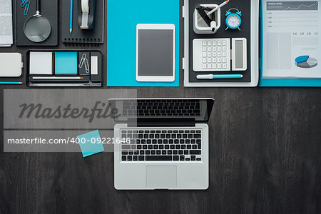 Flat lay corporate business desktop with office accessories and a laptop on a dark background