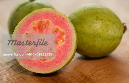 Pink, fresh, ripe guava on wooden table close up