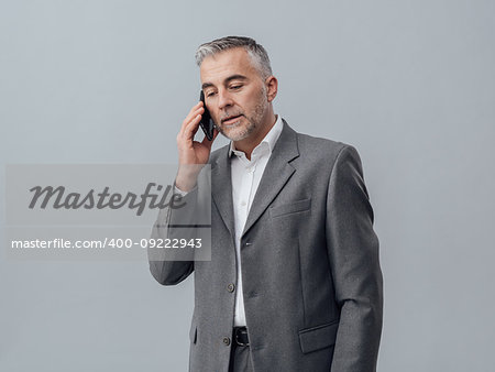 Confident businessman having a phone call with his smartphone