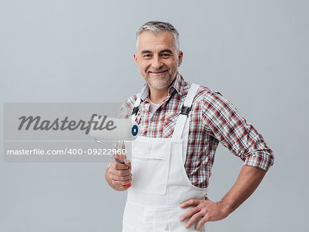 Confident smiling painter and decorator posing with a paint roller