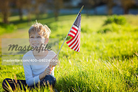 positive little boy with american flag celebrating 4th of july, independence day, or memorial day