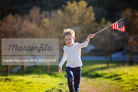 positive little boy with american flag running and celebrating 4th of july, independence day, or memorial day