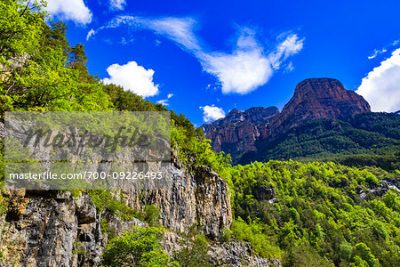 Looking up at rock cliffs and mountain top against a blue sky in Ordesa y Monte Perdido National Park in the Pyrenees in Huesca Province, Aragon, Spain