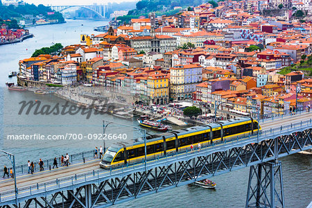 Train on the Dom Luis I Bridge and harbor with the Arrabida Bridge in the distance in Porto, Norte, Portugal