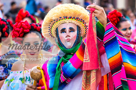 Indigenous tribal dancer and women in traditional costumes at a St Michael Archangel Festival parade in San Miguel de Allende, Mexico