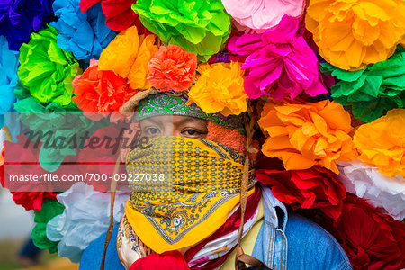 Close-up of indigenous tribal dancer wearing head scarves and colurful flowers at a St Michael Archangel Festival parade in San Miguel de Allende, Mexico