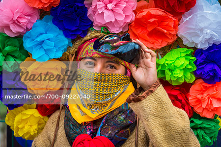 Close-up of indigenous tribal dancer wearing mask and colurful flowers at a St Michael Archangel Festival parade in San Miguel de Allende, Mexico