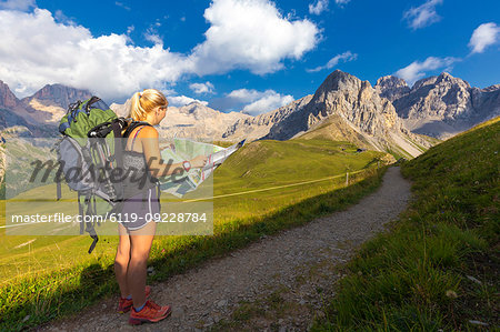 Hiker reading map near San Nicolo Pass, Fassa Valley, Trentino, Dolomites, Italy, Europe