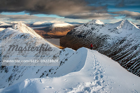 A female walker approaching the summit of Stob Dubh on Buchaille Etive Beag on a crisp winter day, Highlands, Scotland, United Kingdom, Europe