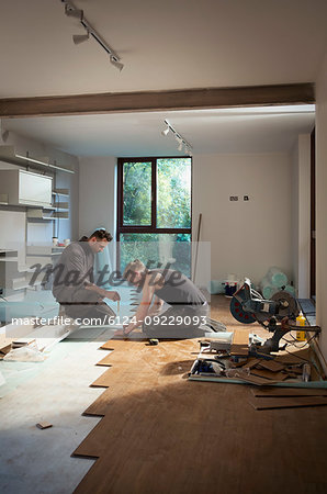 Construction workers laying hardwood flooring in house