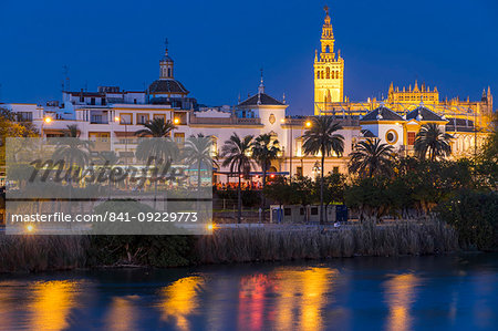 The Giralda Bell Tower and Plaza de Toros seen from the banks of Guadalquivir River at dusk, Seville, Andalusia, Spain, Europe