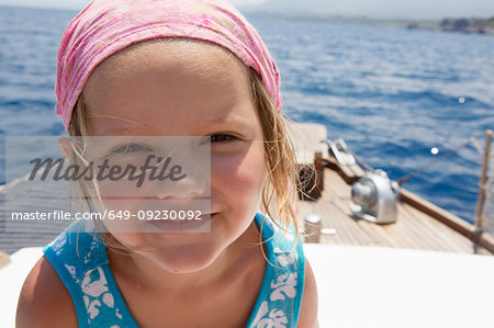 Cute girl on boat wearing headscarf, portrait, Castellammare del Golfo, Sicily, Italy