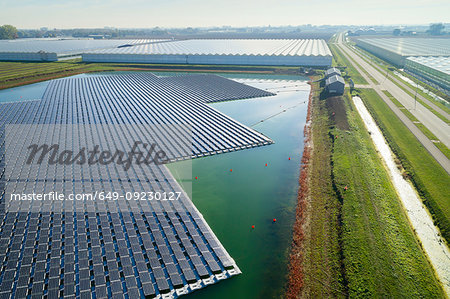 Floating solar panels installed on water supply of neighbouring greenhouses, elevated view, Netherlands