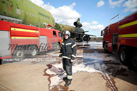 Fire training, fireman by fire engines at training facility, portrait